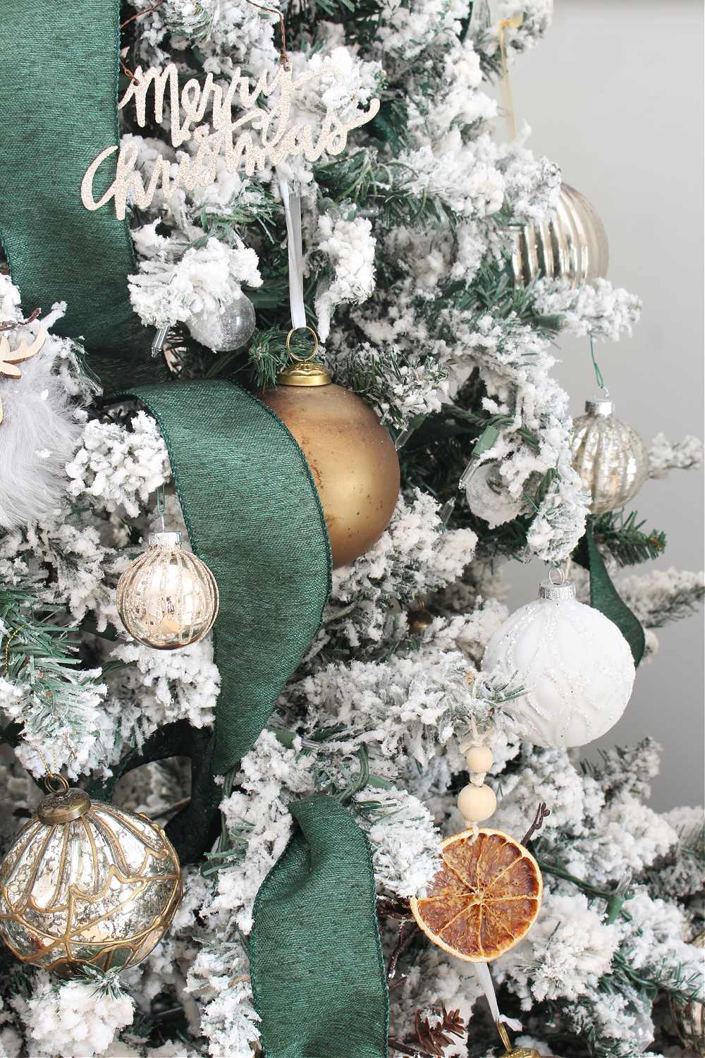 Christmas tree decorated with metallics and dried oranges.