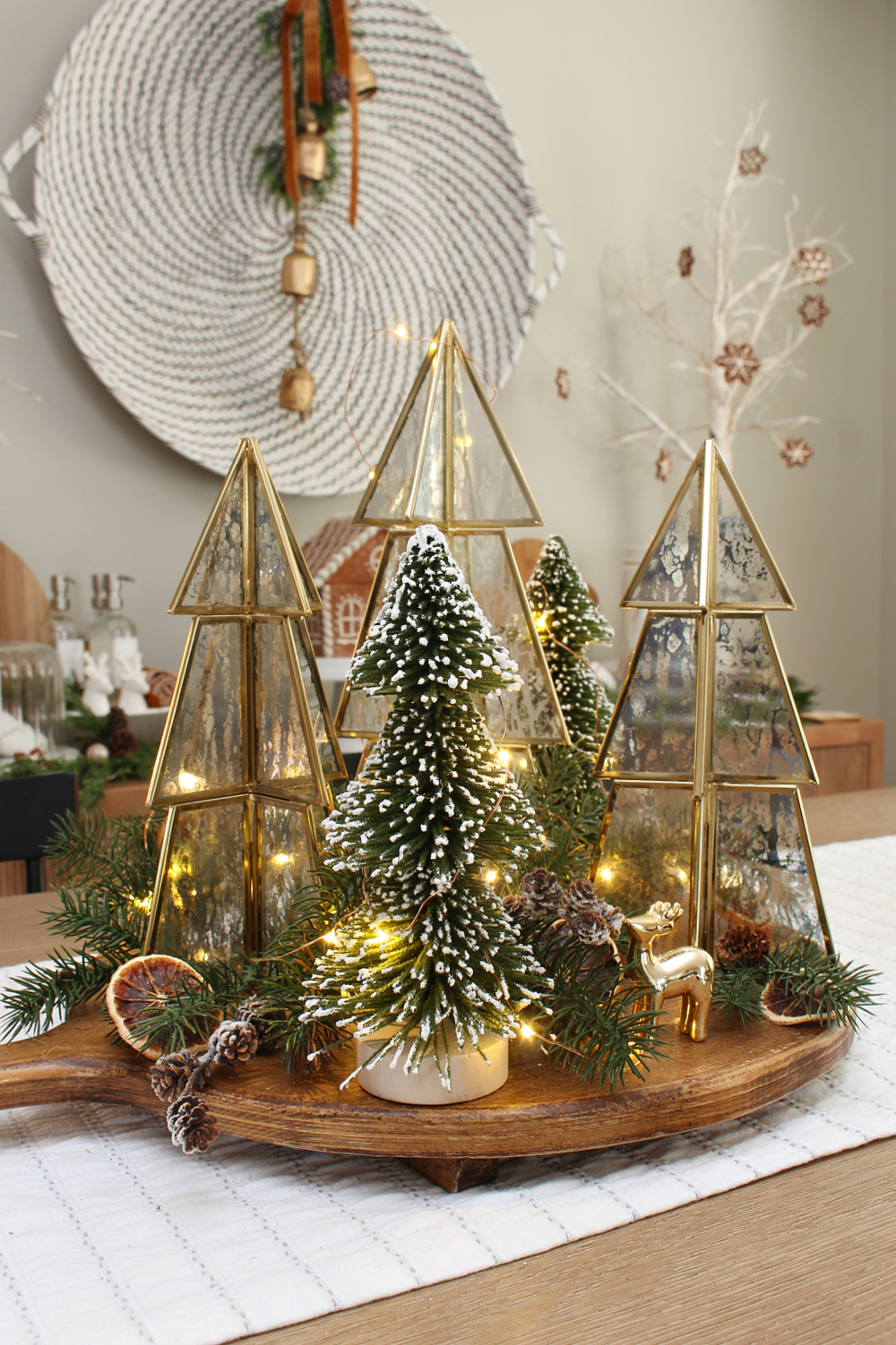 Cute Christmas centerpiece with gold and glass trees, greenery and twinkle lights.