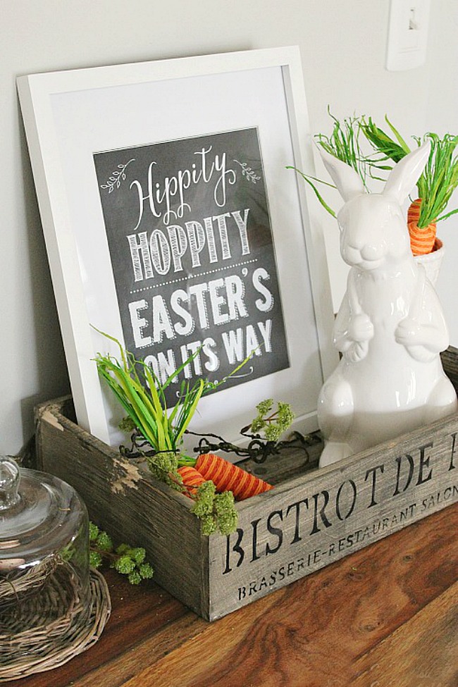 Hippity Hoppity Easter's on its Way printable displayed with a white bunny and carrots.