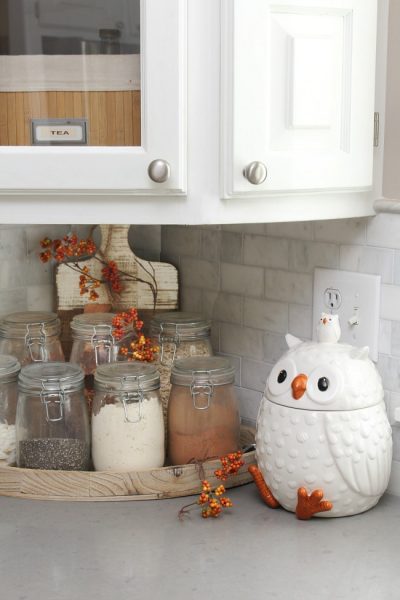 Fall kitchen corner with owl cookie jar and mason jars filled with dry goods.