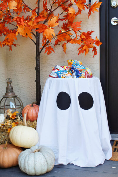 Ghost Halloween candy holder on a porch decorated for Halloween.