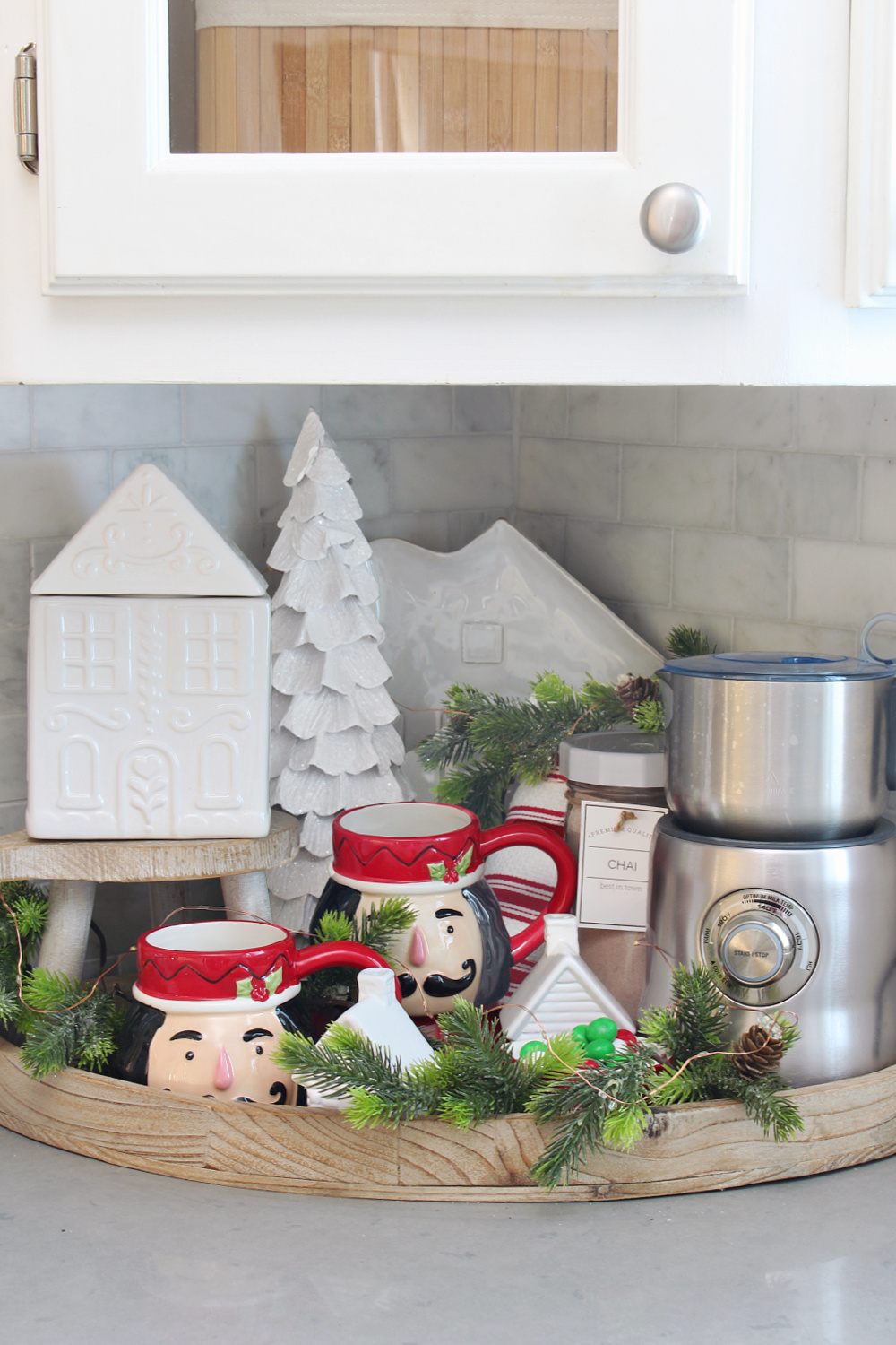 Christmas hot beverage bar tray with Nutcracker mugs, storage jar, and a milk frother.