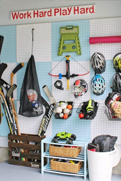 Blue and white checked pegboard organizer for sports equipment.